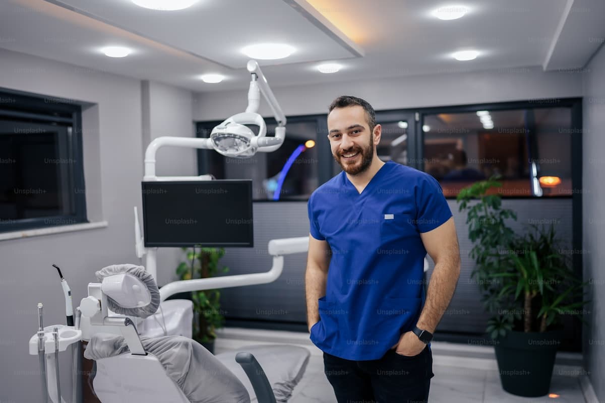 Dentist standing in modern dental office with patient chair and equipment