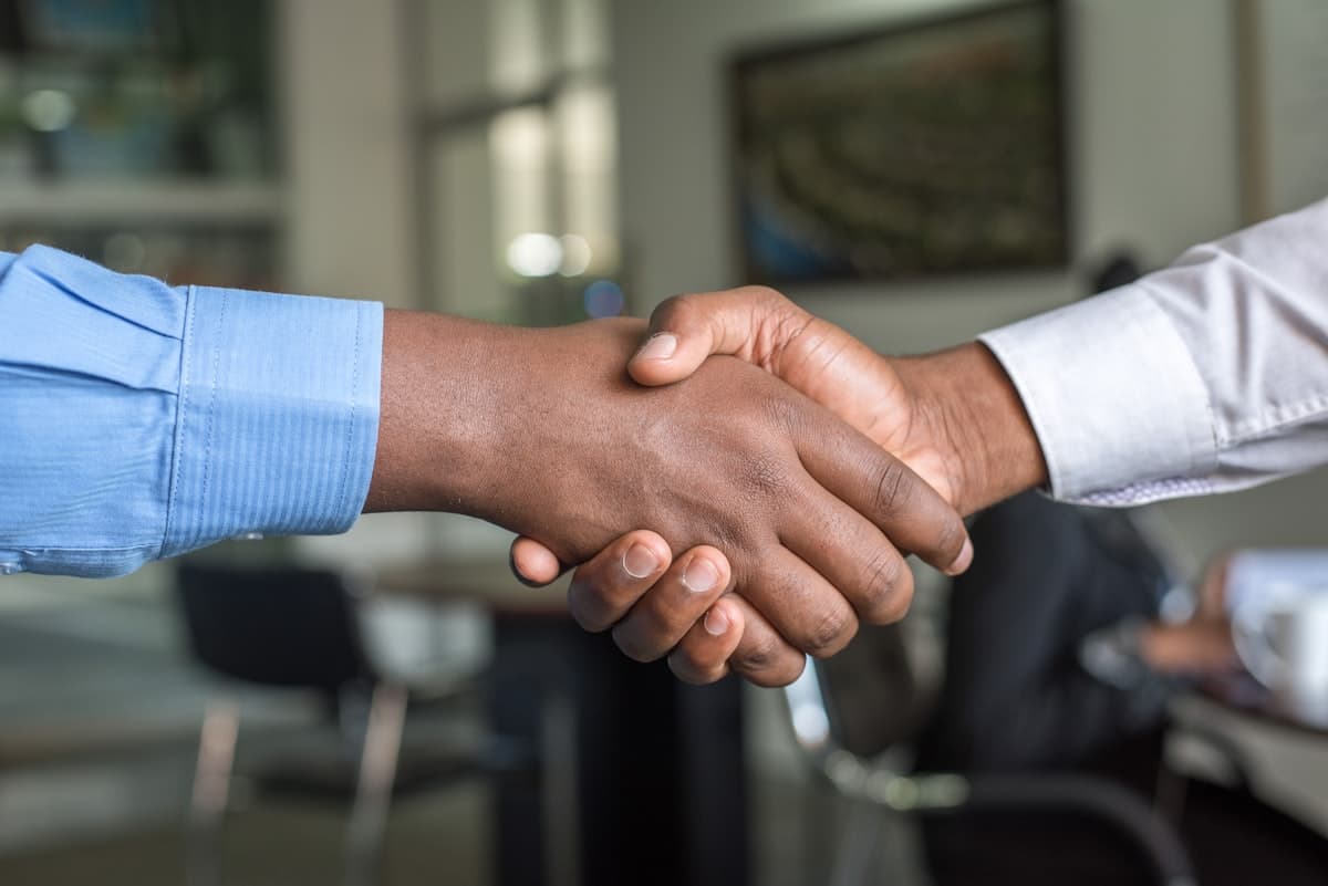 Insurance agent shaking hands with client — VoiceAI handles quote requests while agents close deals