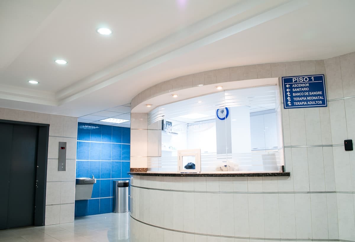 Bright medical practice waiting room with reception desk and patient seating